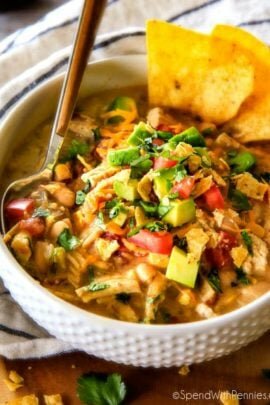 White Chicken Chili in a white bowl with a spoon and tortilla chips