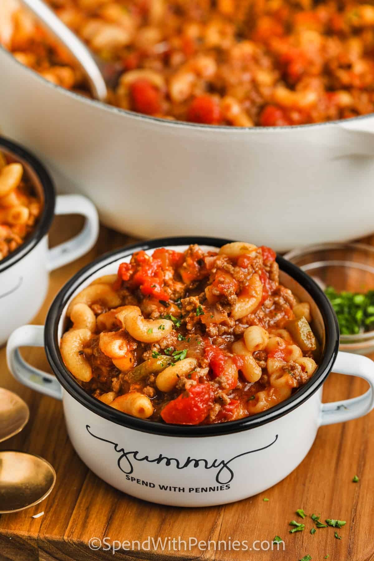 American Goulash in bowls with a pot full in the back