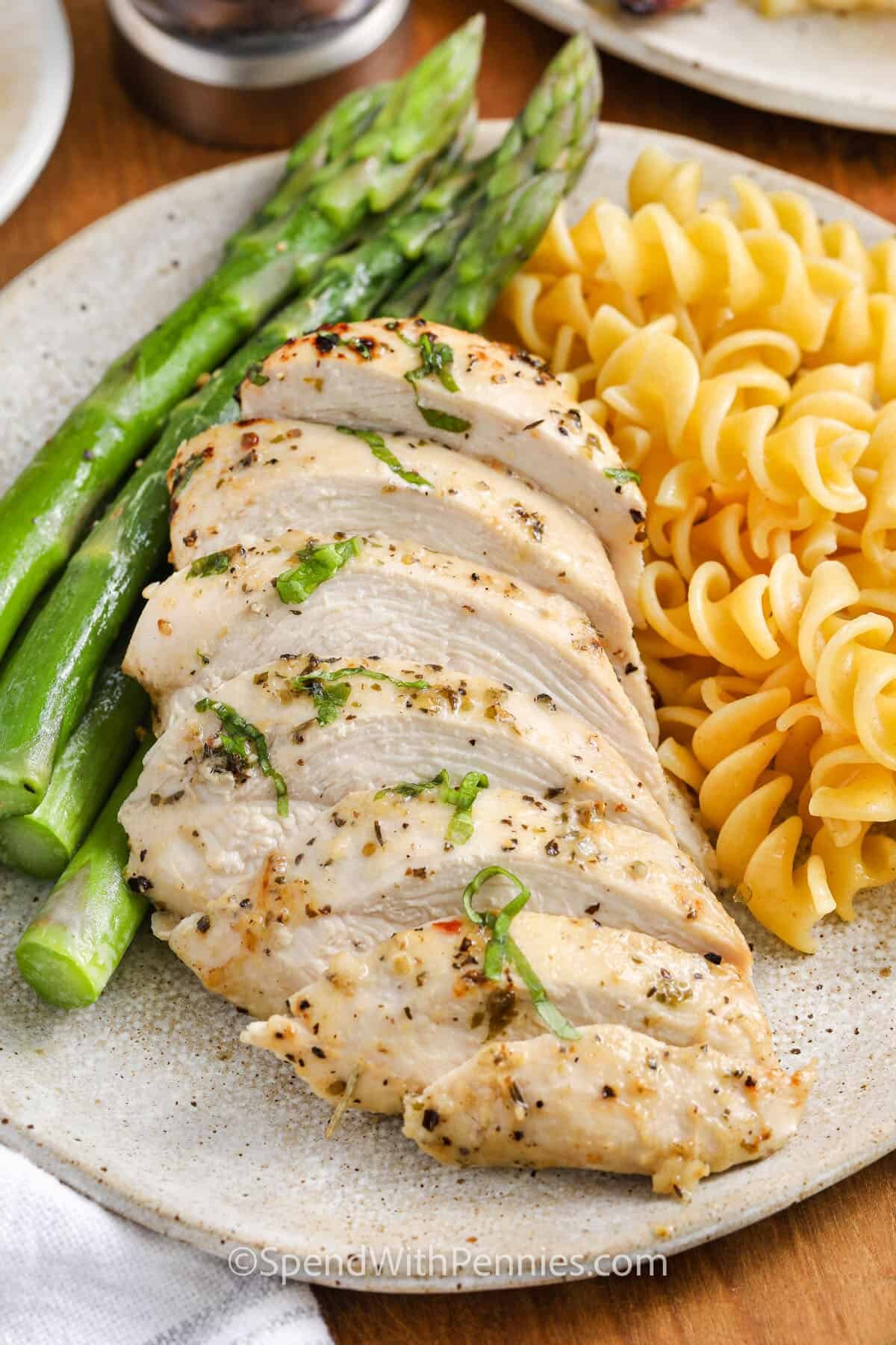 Italian Chicken Marinade on plated chicken with noodles and asparagus