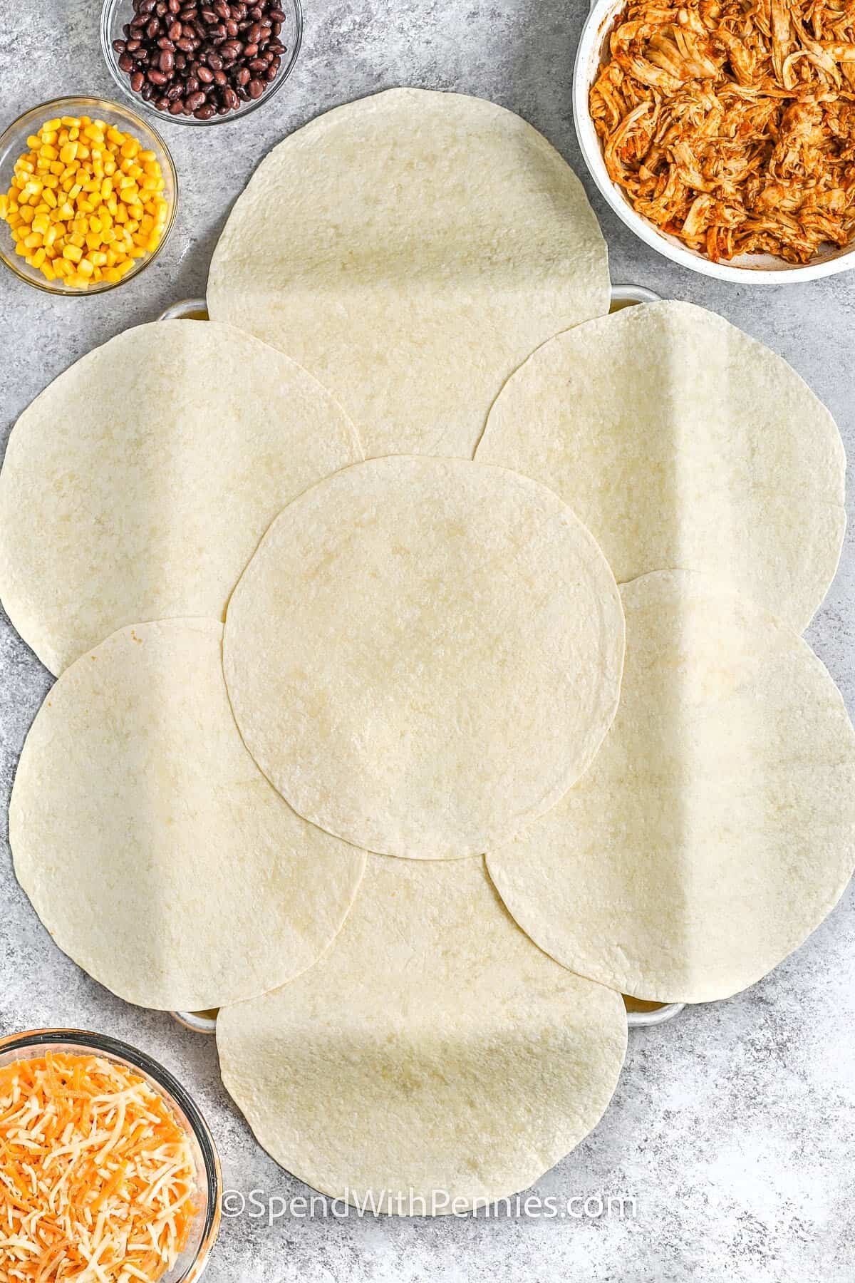 adding tortillas to sheet pan to make Sheet Pan Quesadillas